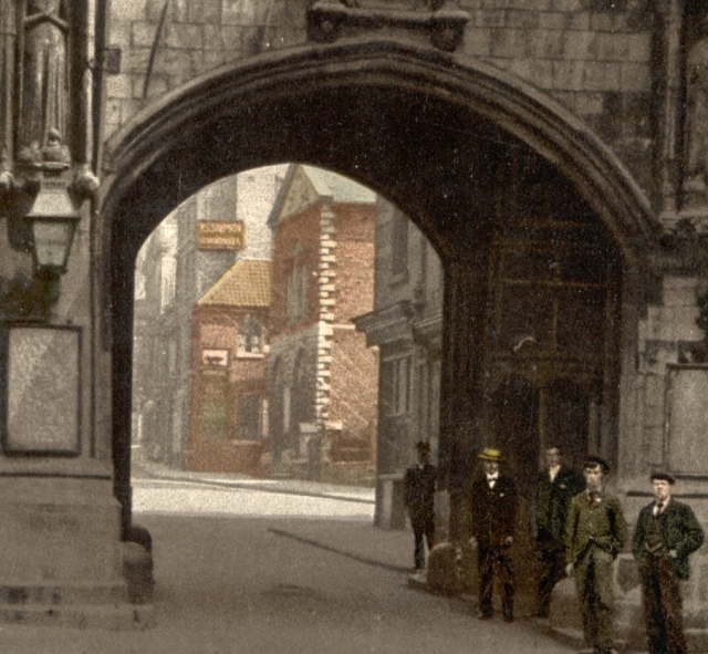 The Butter Market with the City Assembly Rooms above (the red brick building on the right, prior to being pulled down in the 1930s), as glimpsed through the Stonebow on Lincoln High Street.